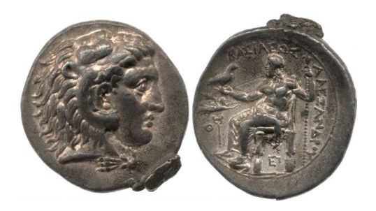 Double-sided silver coin. On the left, one side of the worn coin displays the head of young Herakles with a lion's main and possible ram's horns. On the right, the other side of the coin displays a sitting Zeus holding an eagle in an outstretched right hand and a scepter in the raised left arm.