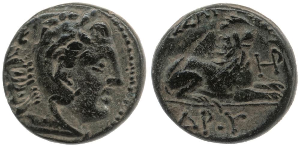 Double-sided copper coin. On the left, one side of the coin displays a horned Heracles wearing lionskin. On the right, the other side of the coin displays a lion laying down with its head raised.