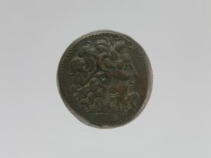 Head of a coin depicting a ram-horned Ptolemy II wearing a diadem and facing the right.